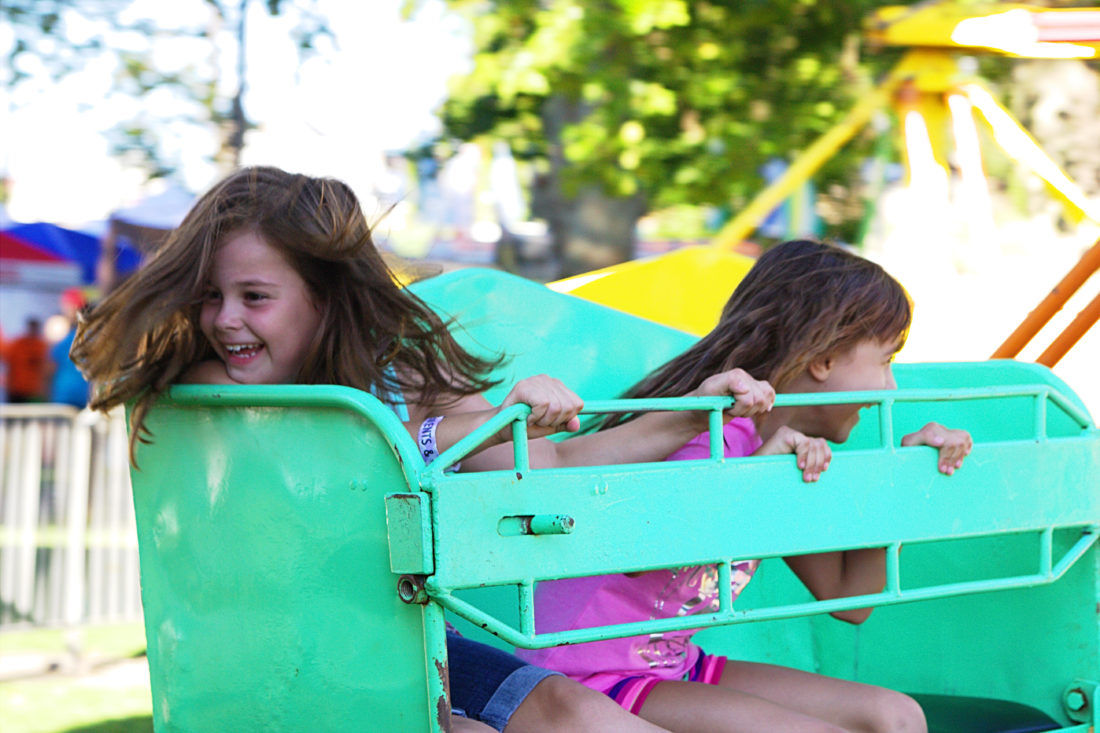 Two children enjoying a ride at the fair.